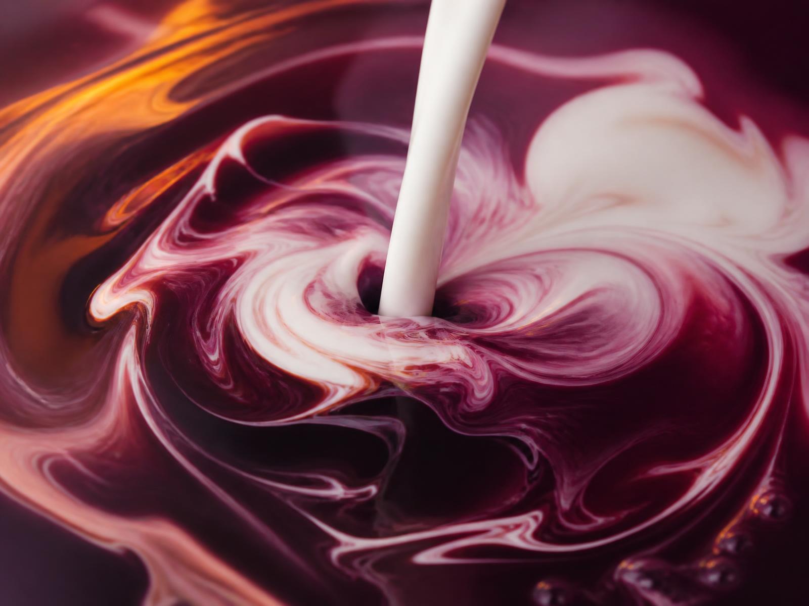 A pour of milk swirling into deep plum, marbled with cream ribbons
